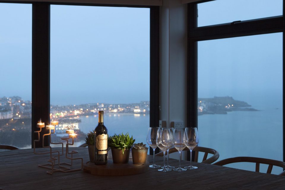 Architecture photographers in Cornwall: Interior shot of a dining table looking out over the ocean.