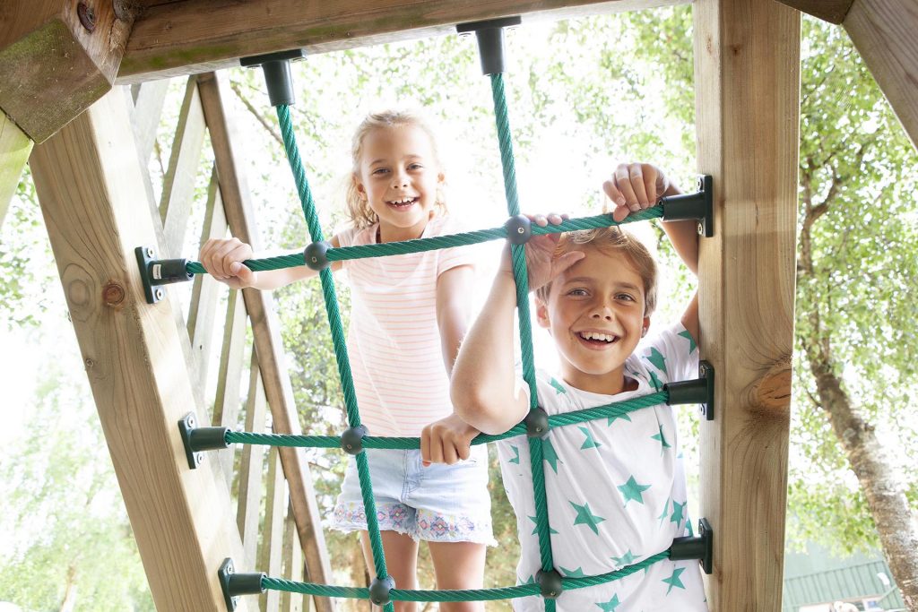 Two children climb the ropes in the playpark
