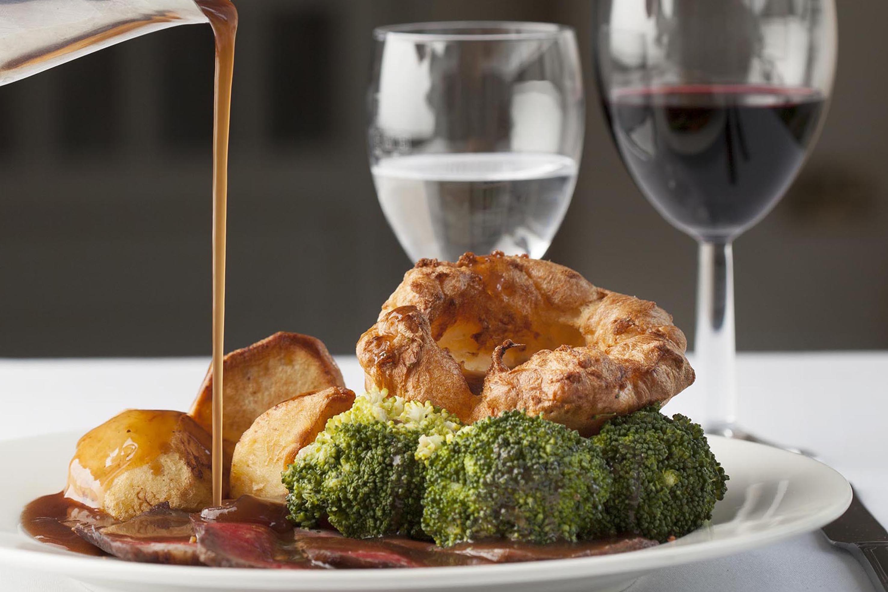 Gravy being poured over a roast dinner