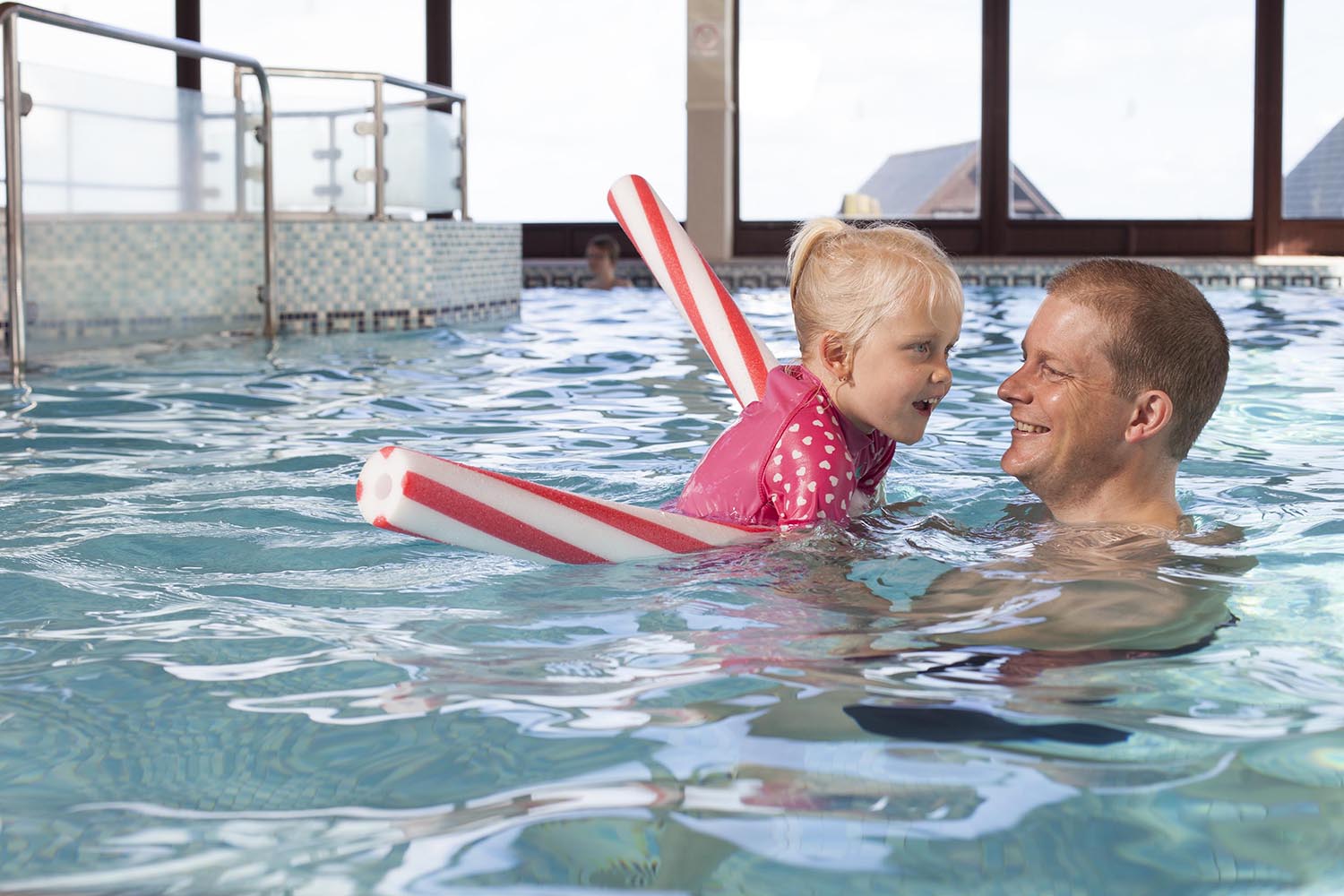 Father and daughter in the swimming pool together
