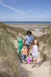 Family enjoy beach holiday in Wales campsite caravan.